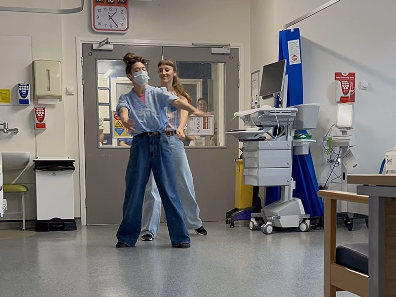 2 people performing for patients in a hospital ward