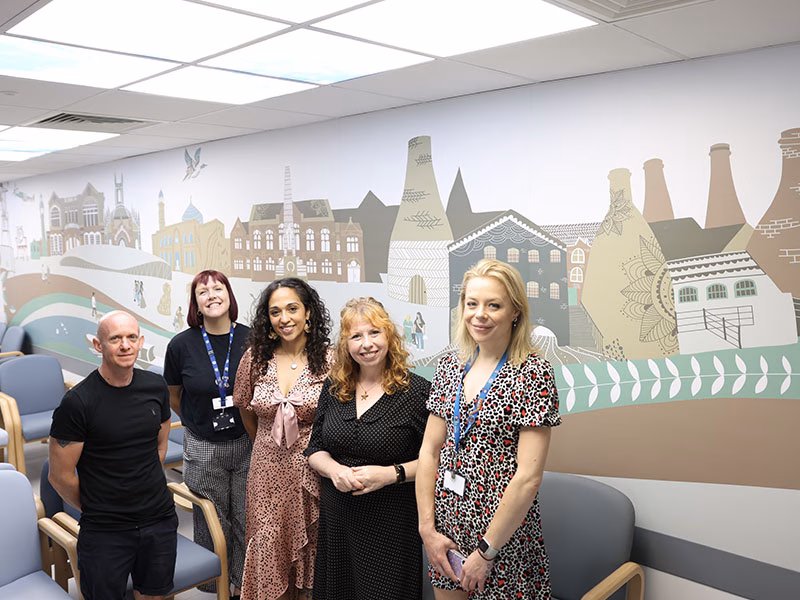 5 people standing in front of a mural on a wall depicting the potteries